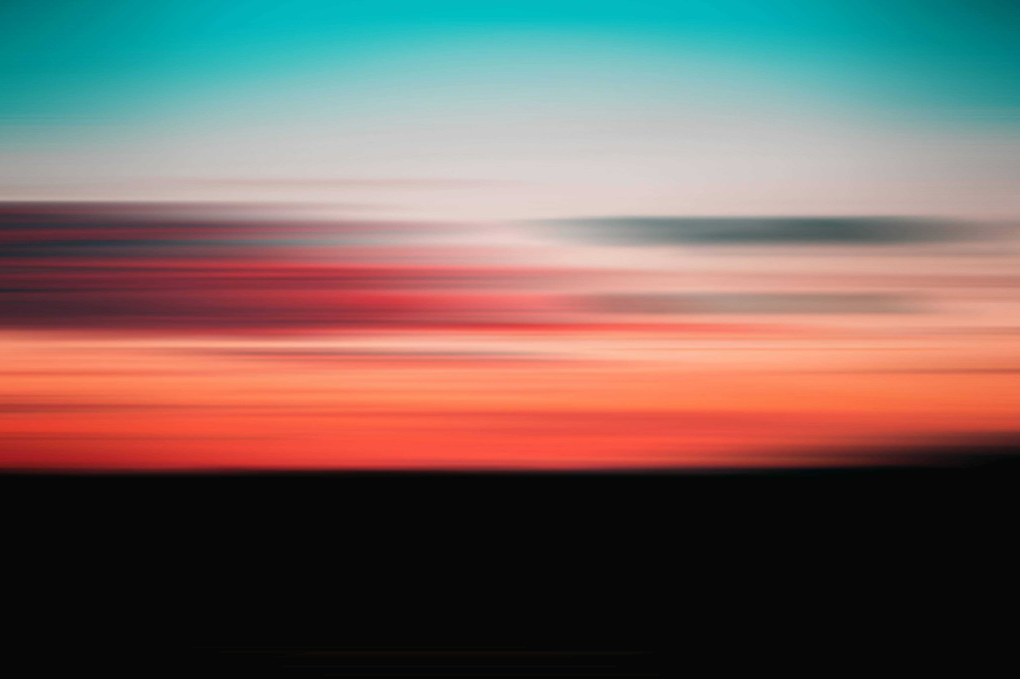 a blurry photo of a sunset with a plane flying in the sky