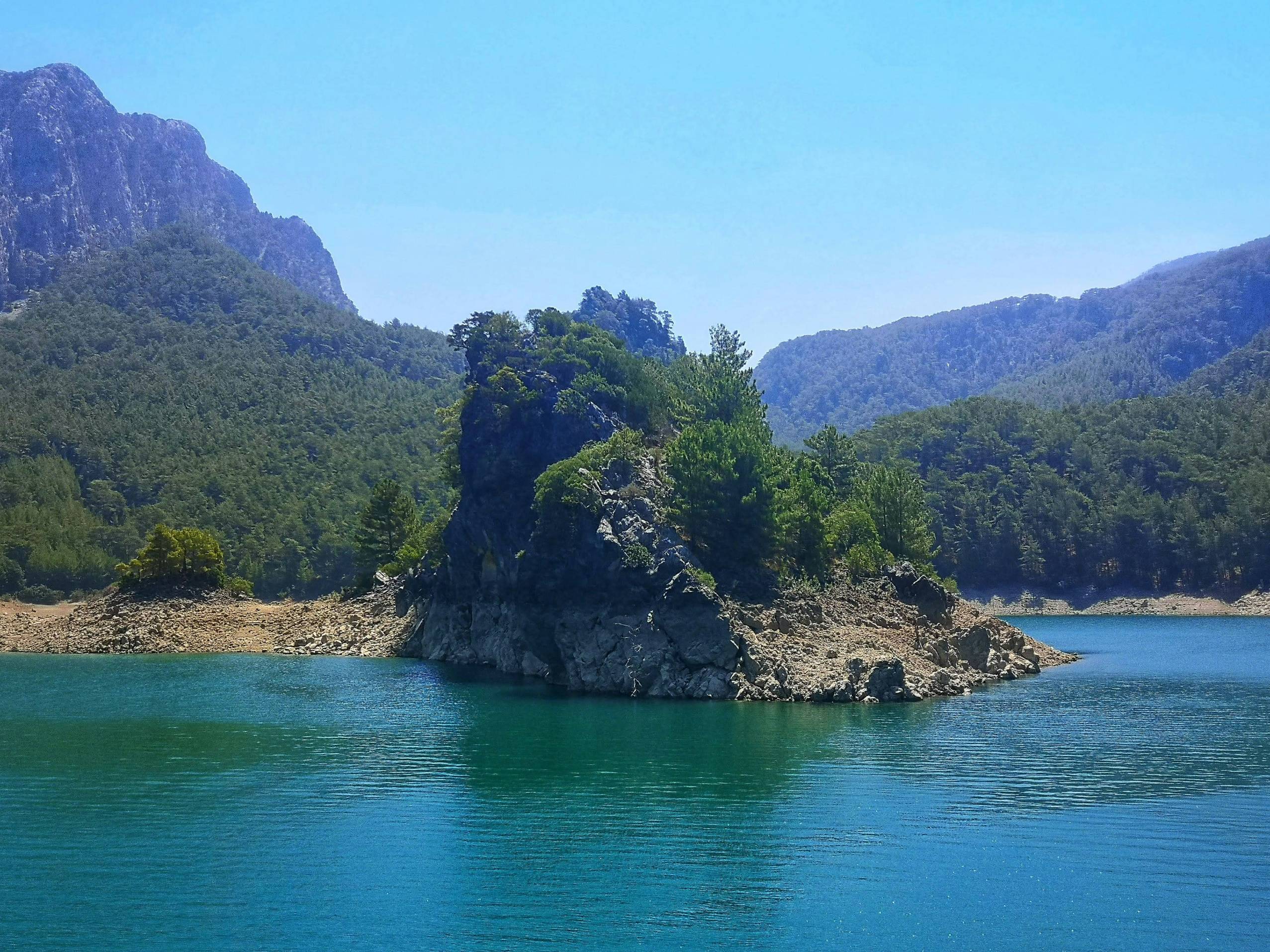 a rocky island with trees and mountains
